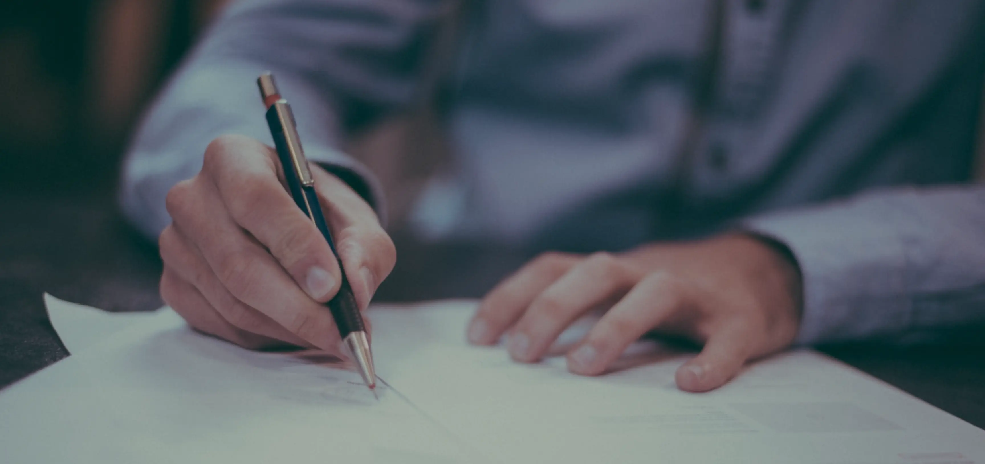 man in suit signing papers